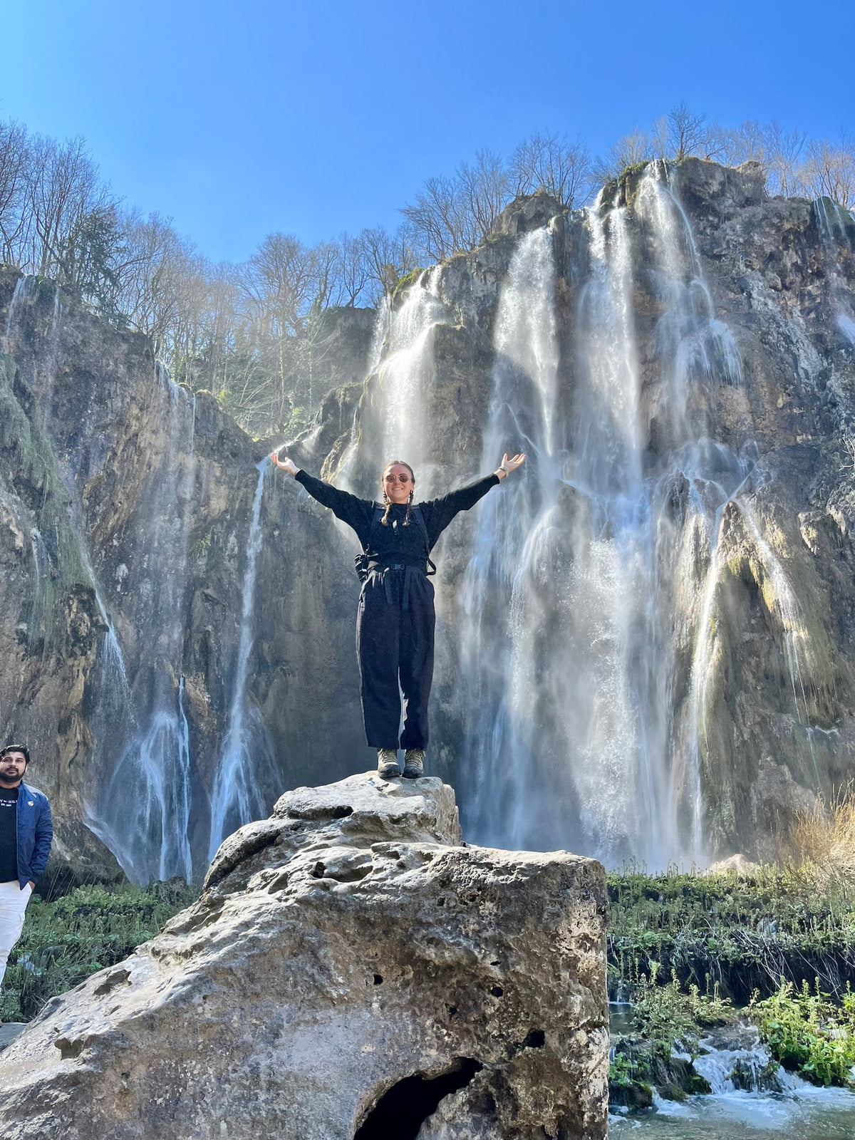Kirsty Cook, founder of House of Arlo, standing in front of a waterfall